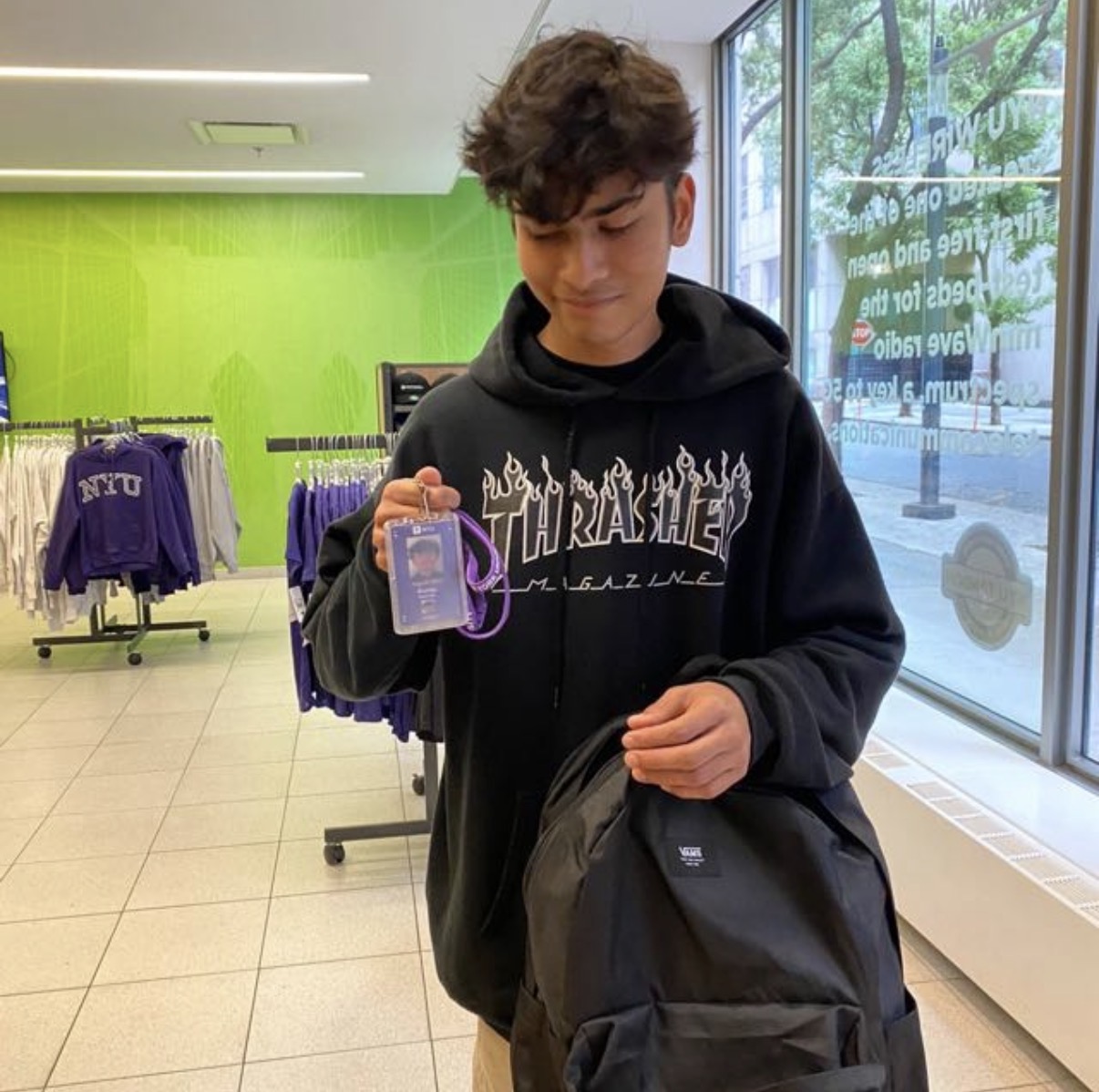 Kanishk holding an ID badge in a store