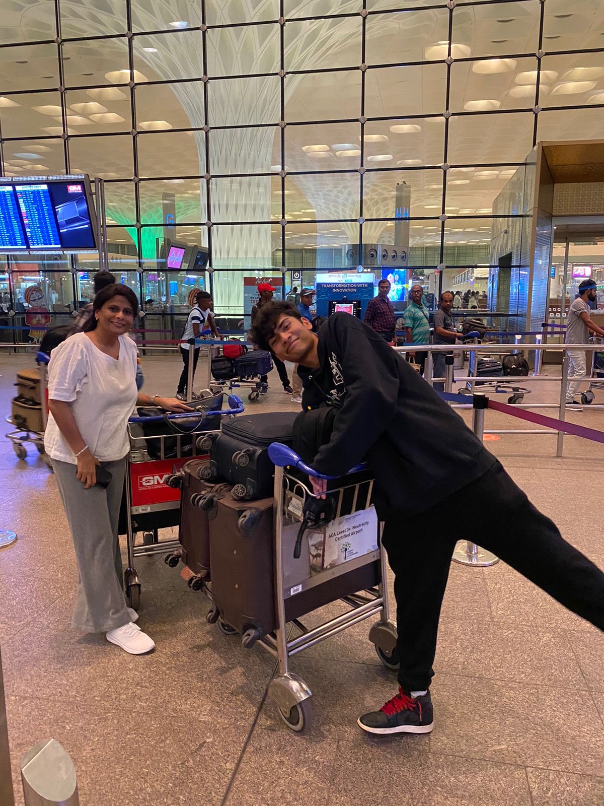 Kanishk and his mother with luggage at the airport